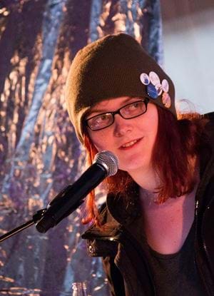 A photo of Natalie Clayton in front of a microphone