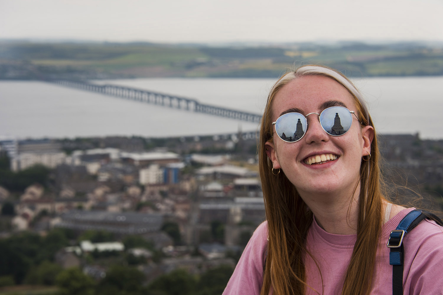 Student on top of The Law with rail bridge behind