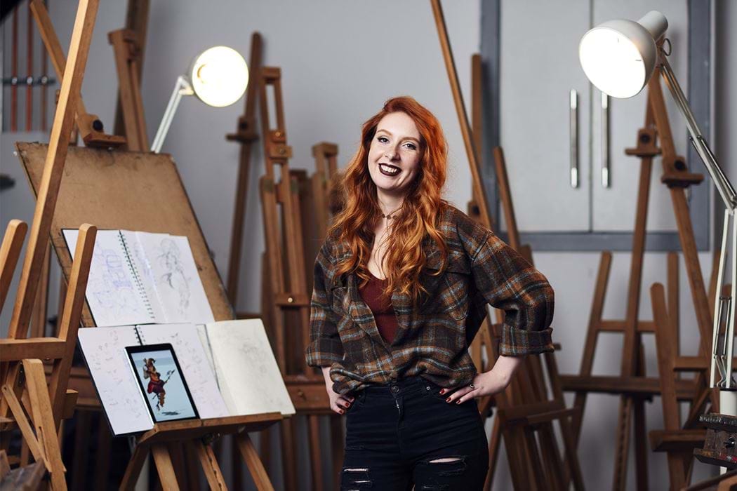 A female standing in front of an art easel
