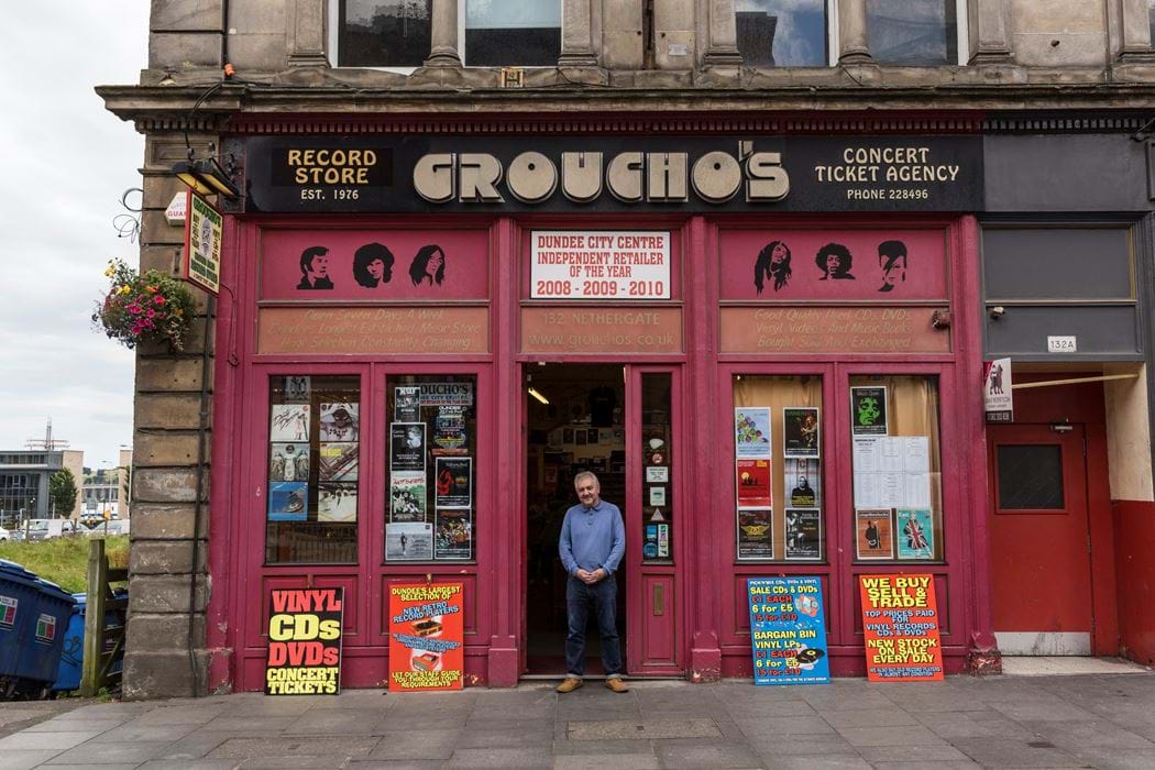 Male standing outside Groucho's shop