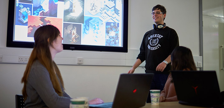 Classroom environment - male standing up talking - people sitting listening