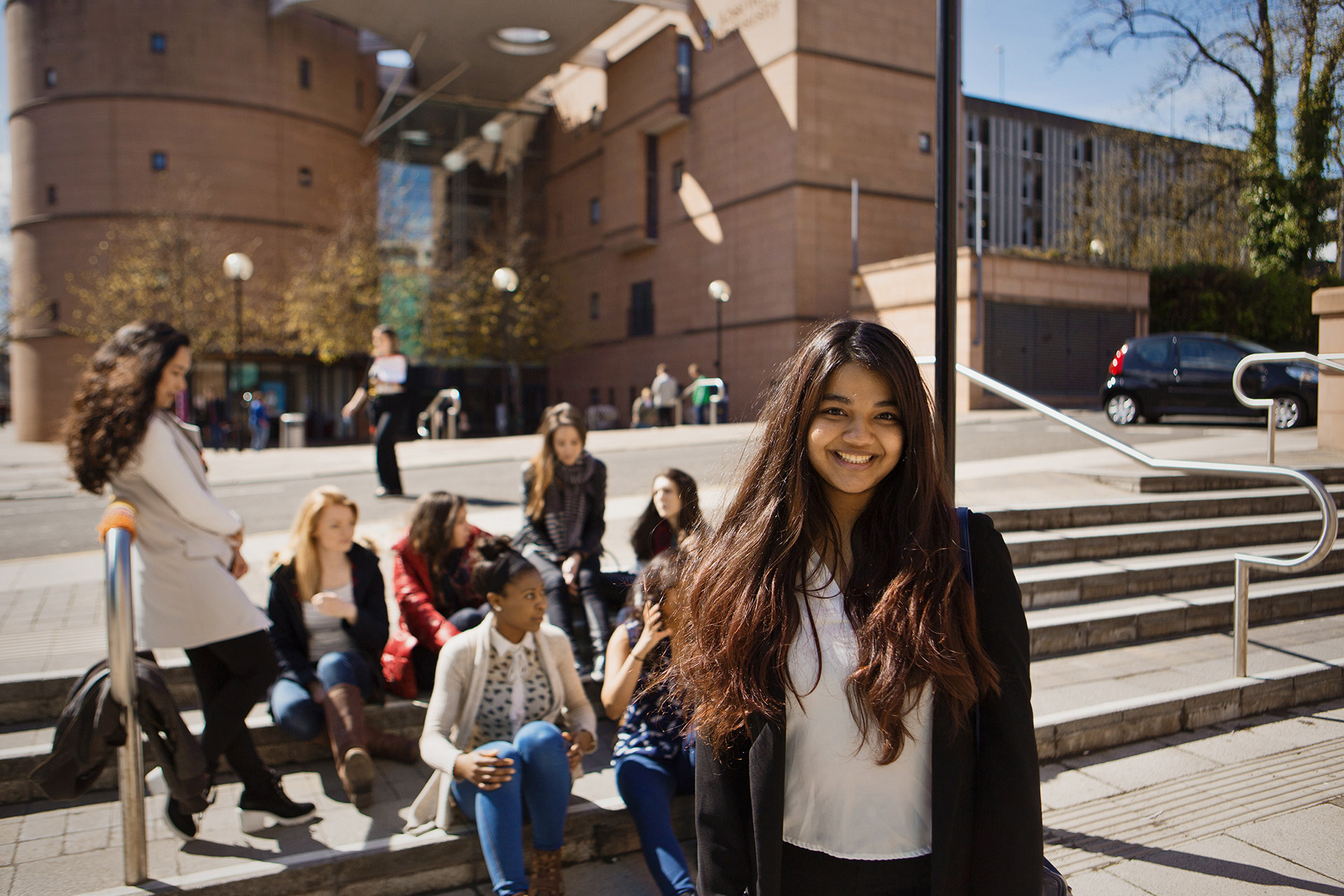 Group of people sitting on steps outside The Bernard King Library