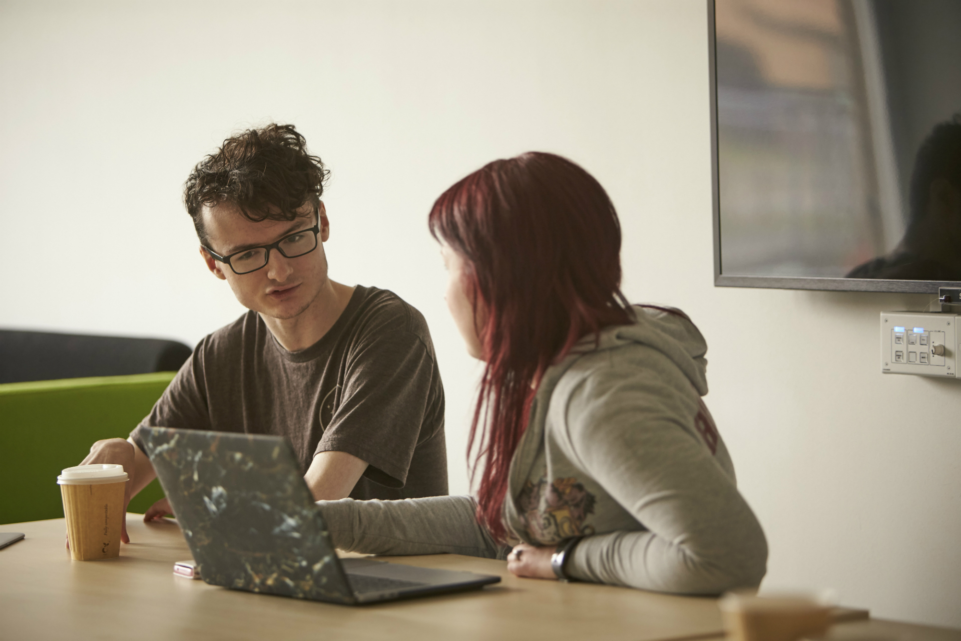 Male & female working together in front of a laptop