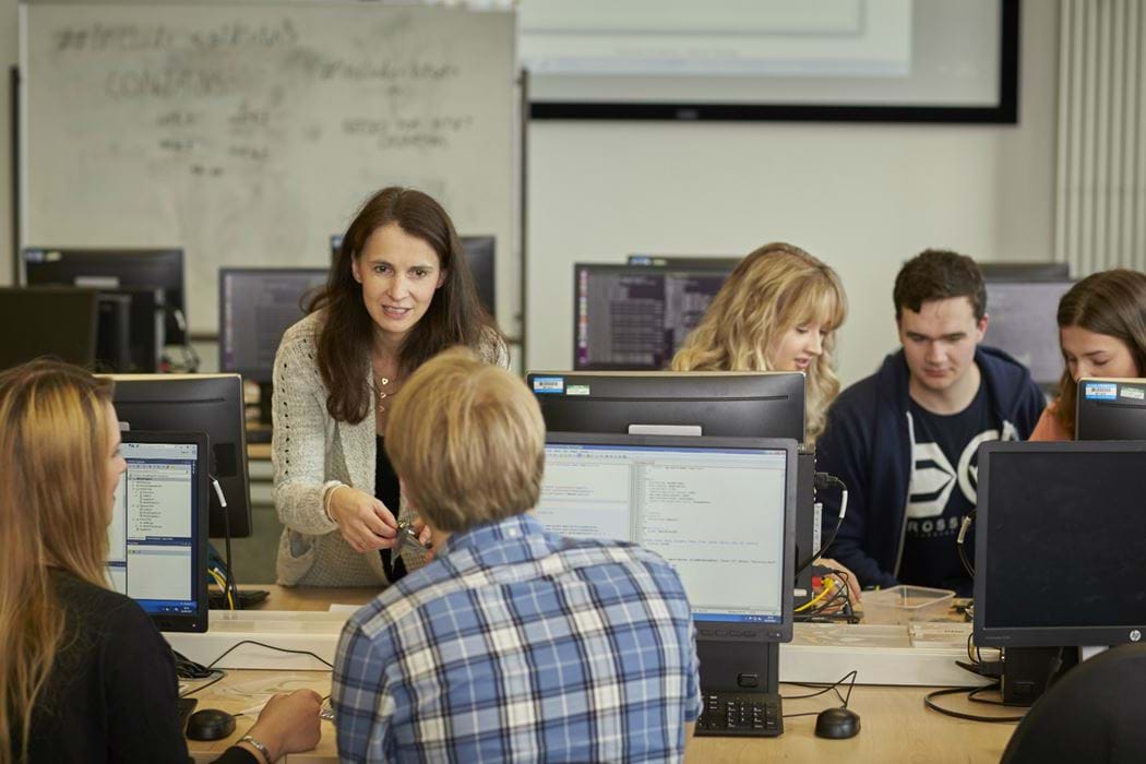 Lecturer and students working in the Hacklab on Desktop computers