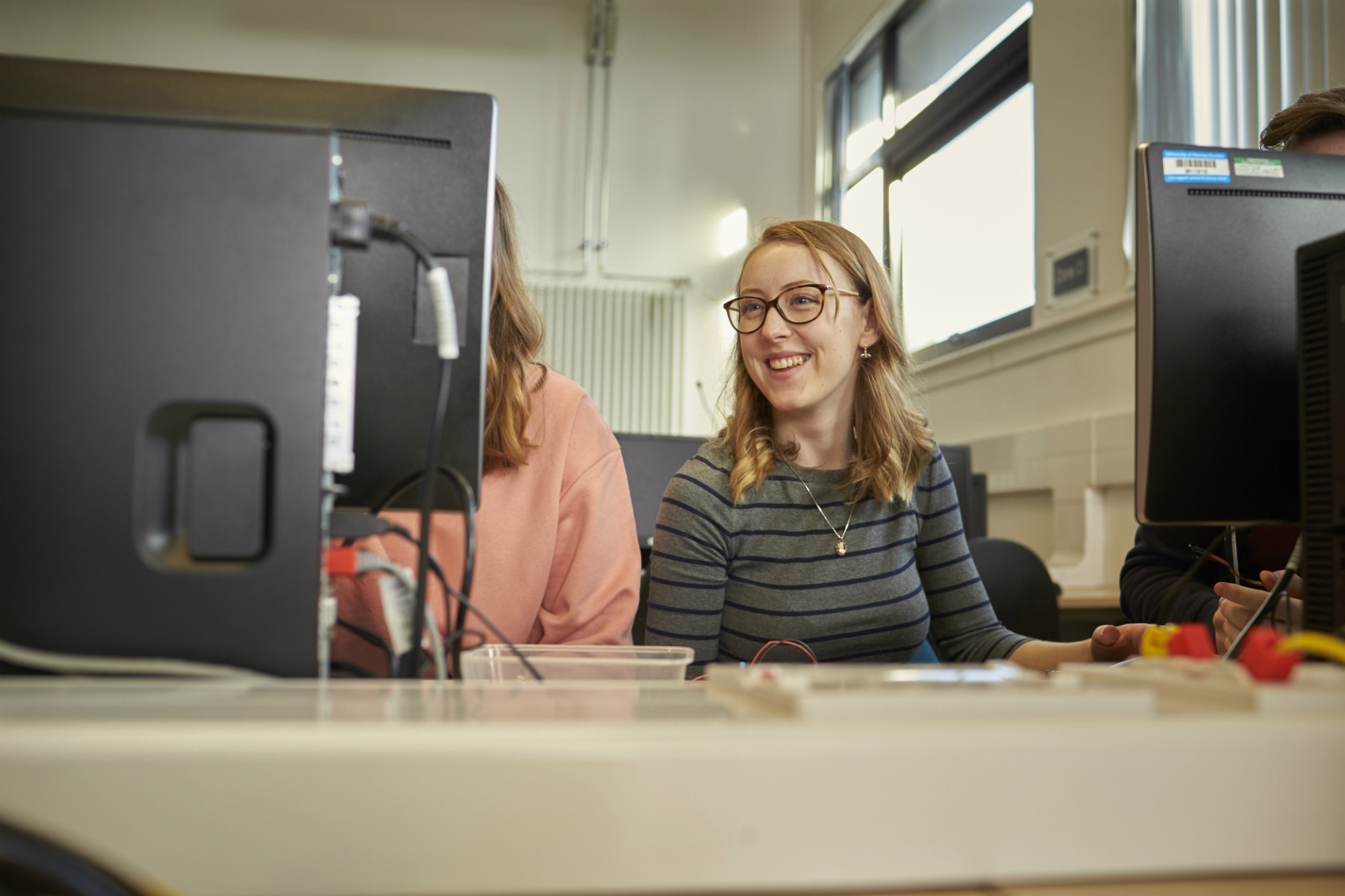Female smiling whilst looking at a computer screen