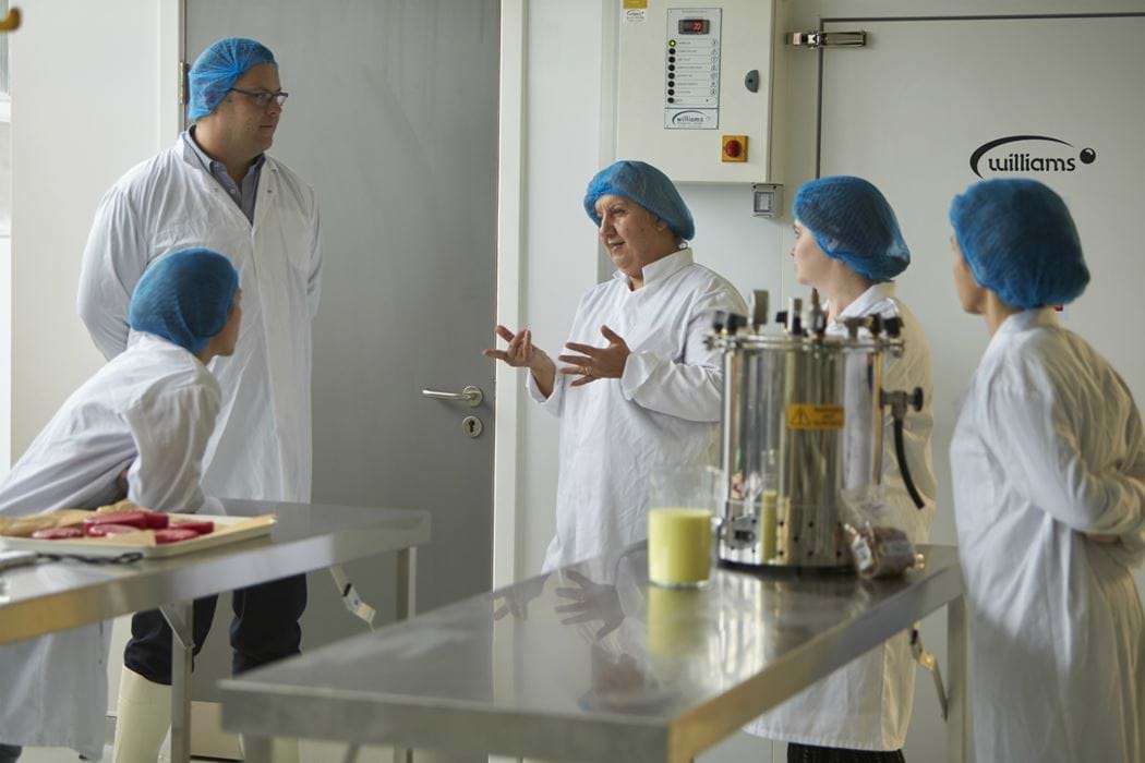 Group of people standing chatting in a food laboratory
