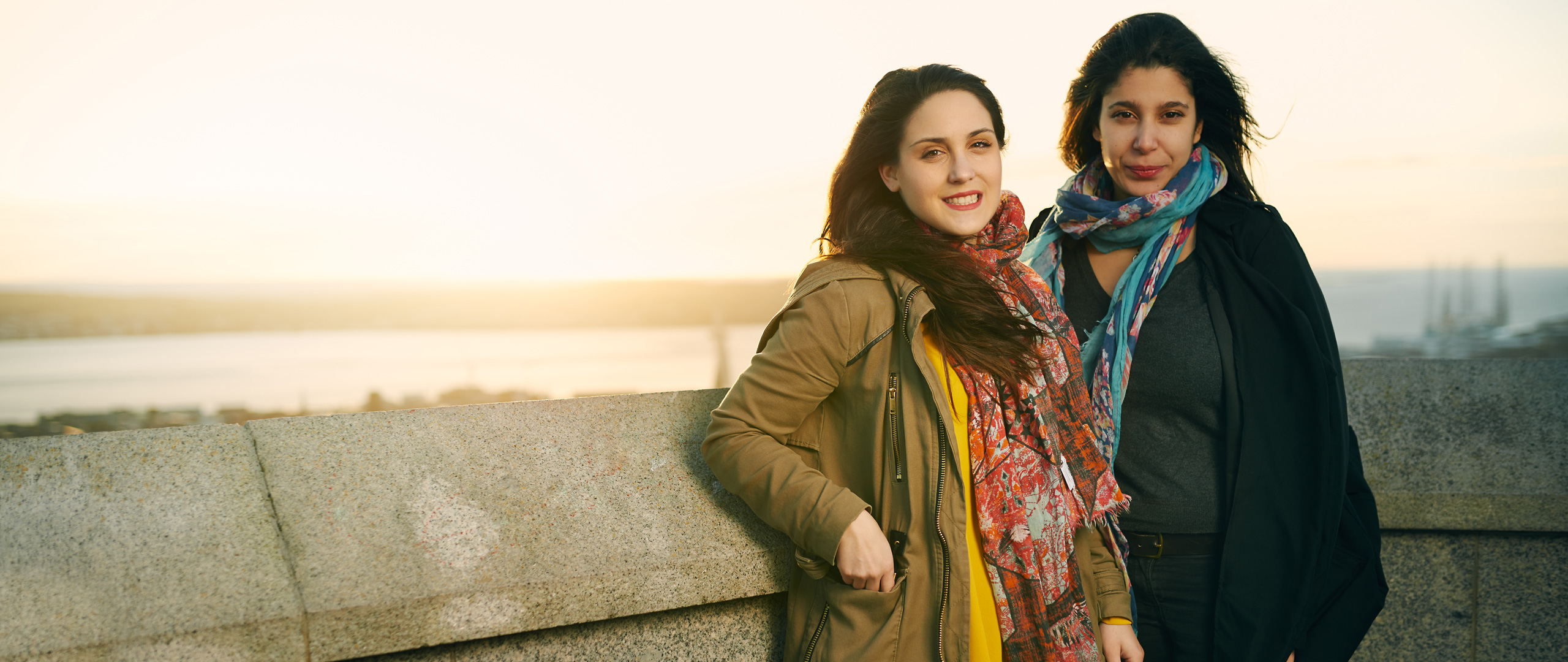 2 females standing in front of water