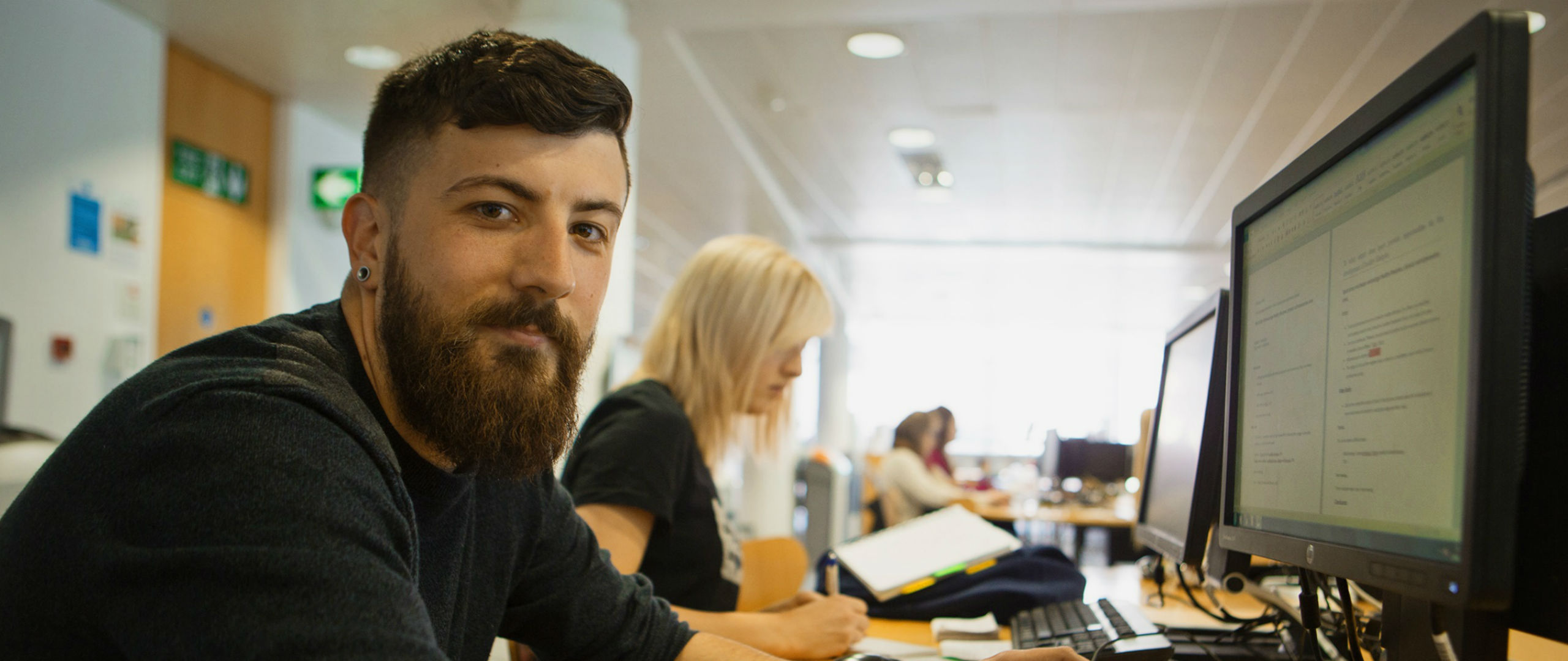 Male and female working on Desktop computers