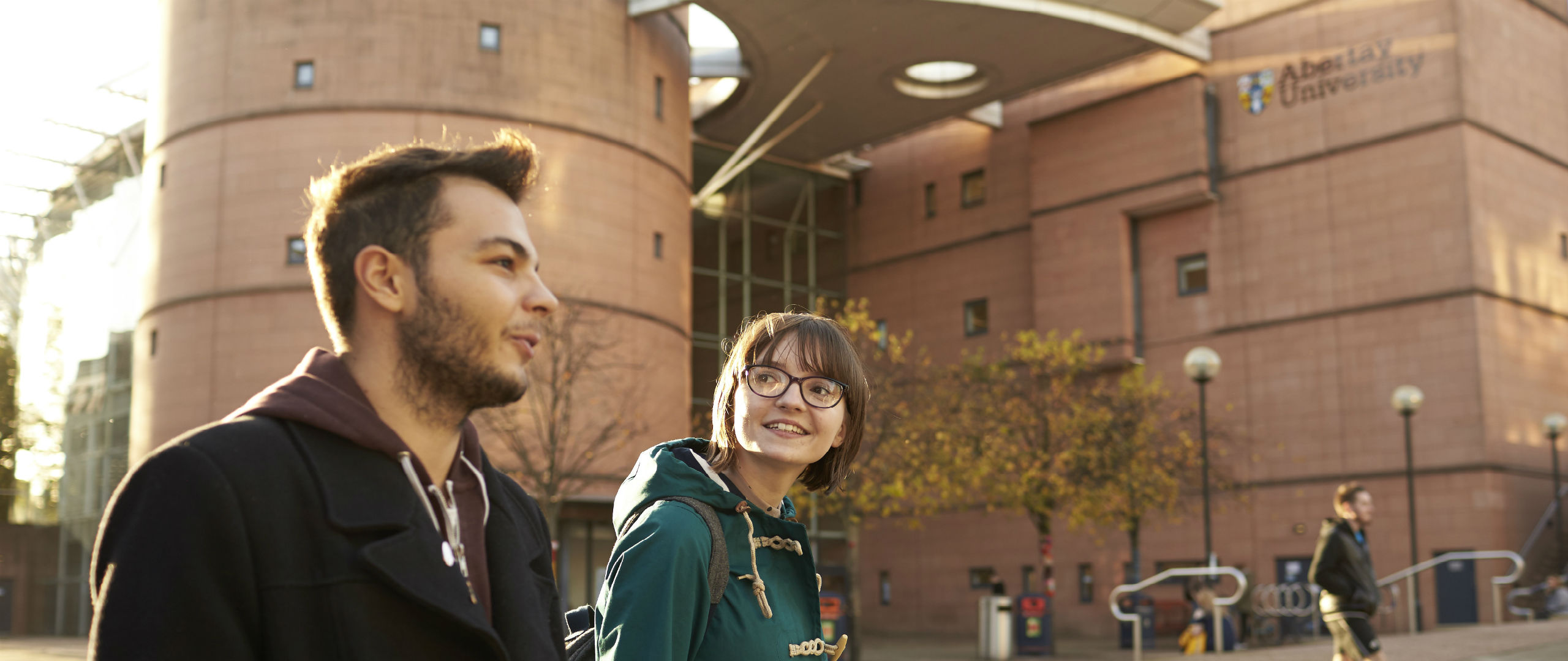 Male and female walking along a street chatting