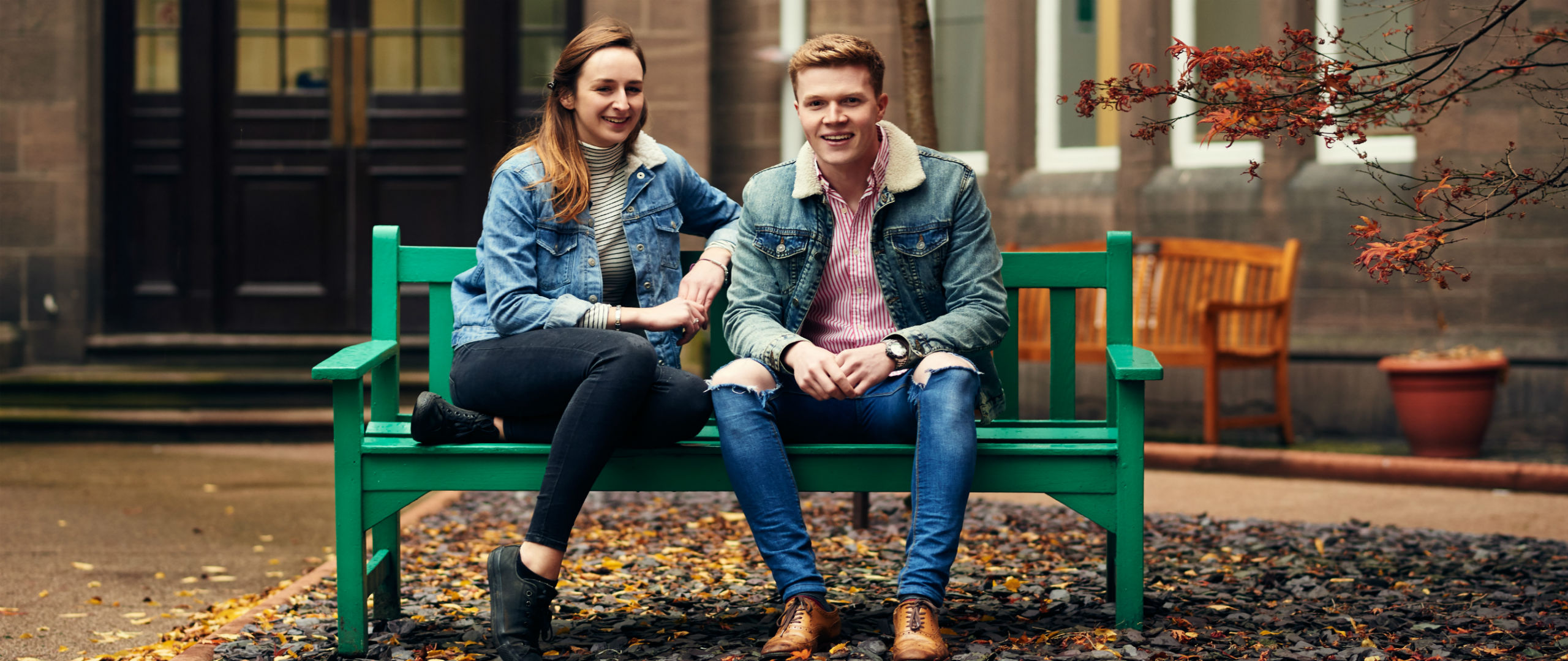 male and female sitting on a bench