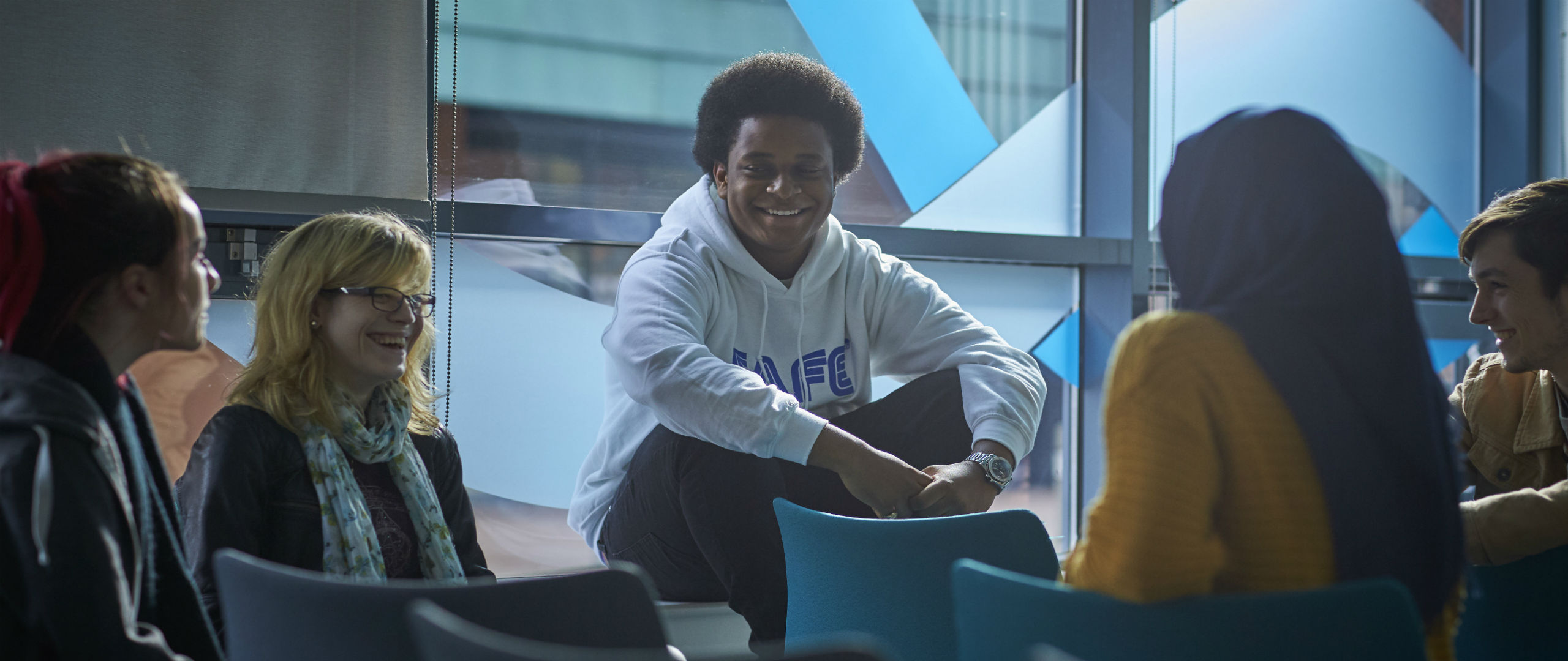 A group of students sitting in the Abertay University events space.