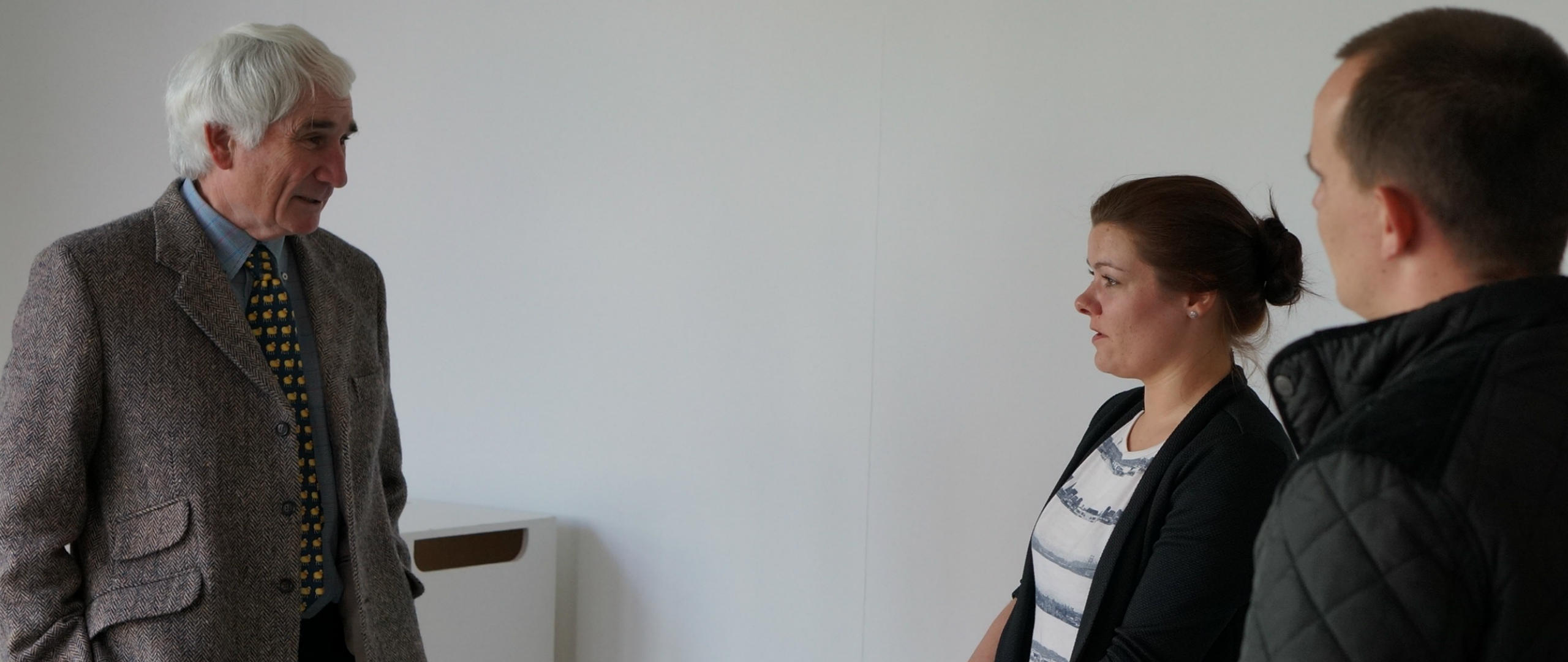 Three people standing chatting