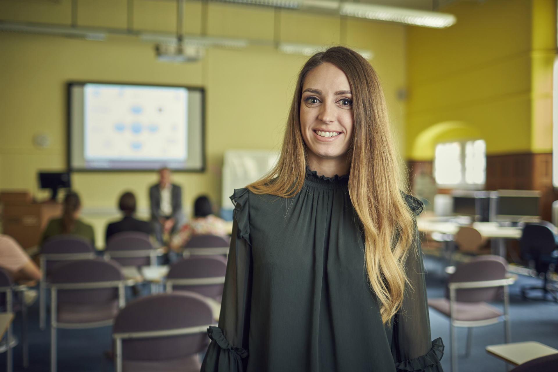 Smiling female - classroom environment in background