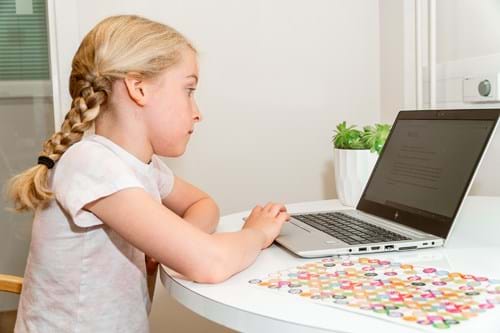 Girl at a desk with a computer doing an experiment