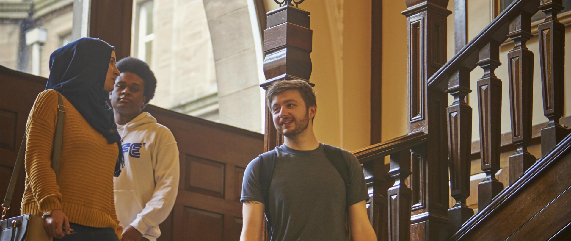 Three people walking down a staircase