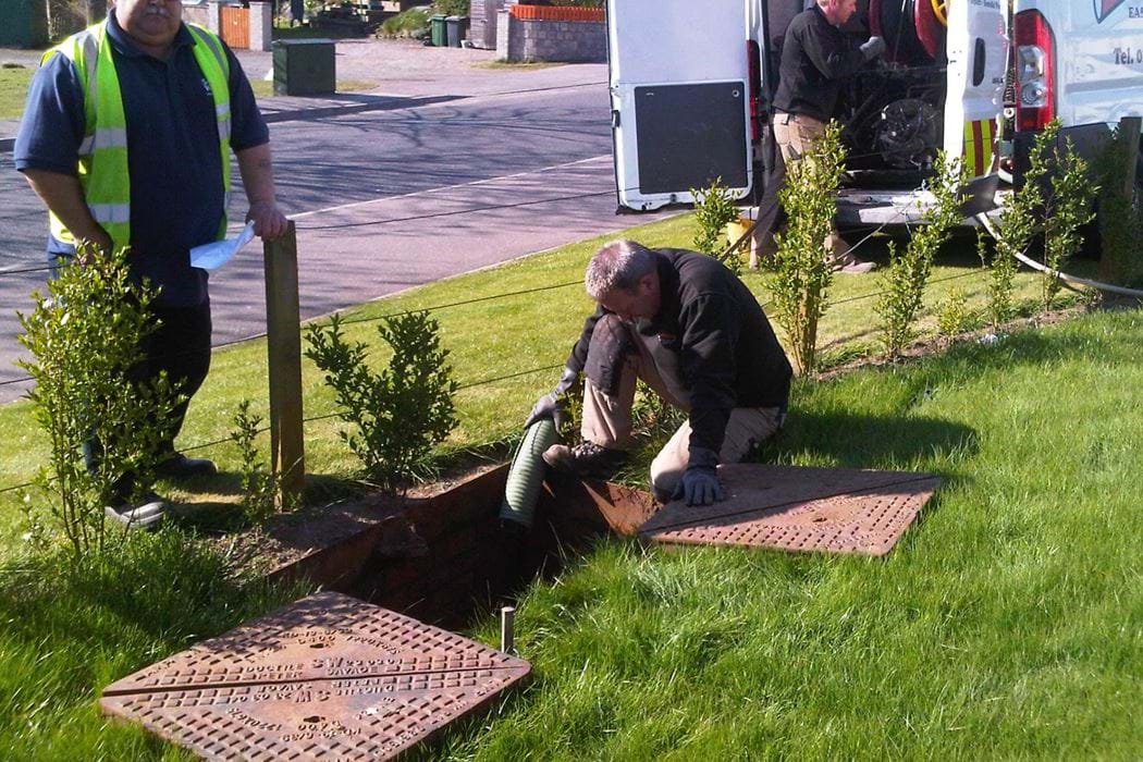 Workmen carrying out repairs to a filter drain