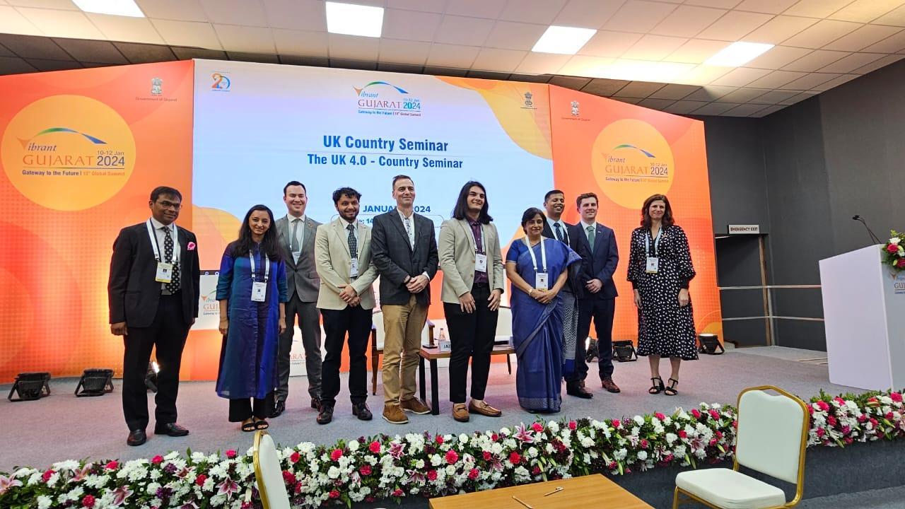 A group of delegates standing on a stage at the Vibrant Gujarat Summit in India.