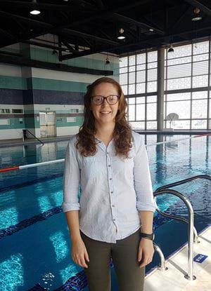 A picture of Alison Chapman standing beside a swimming pool. 