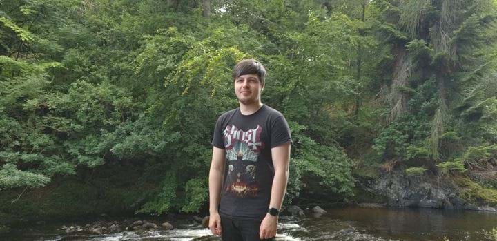 A photo of Kieran McGurk standing by a river