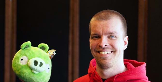 A picture of Pasi Pitkanen holding a stuffed toy of a pig from the game Angry Birds