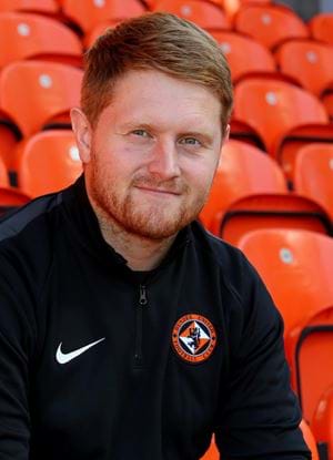 A photo of Michael Malone sat in the stands at Tannadice