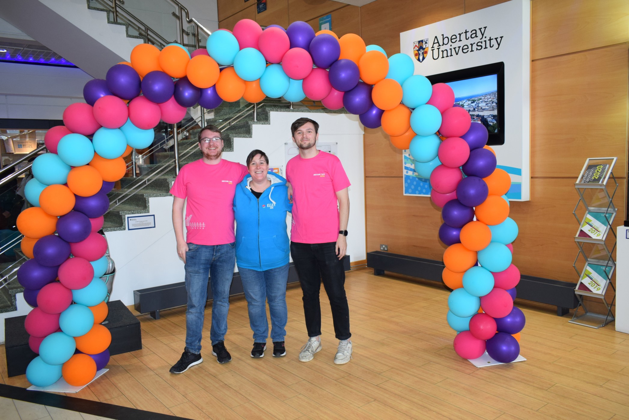 A picture of James McGoldrick and Ross Donald of the Ethical Hacking society with Elley Petrie of the Student Association