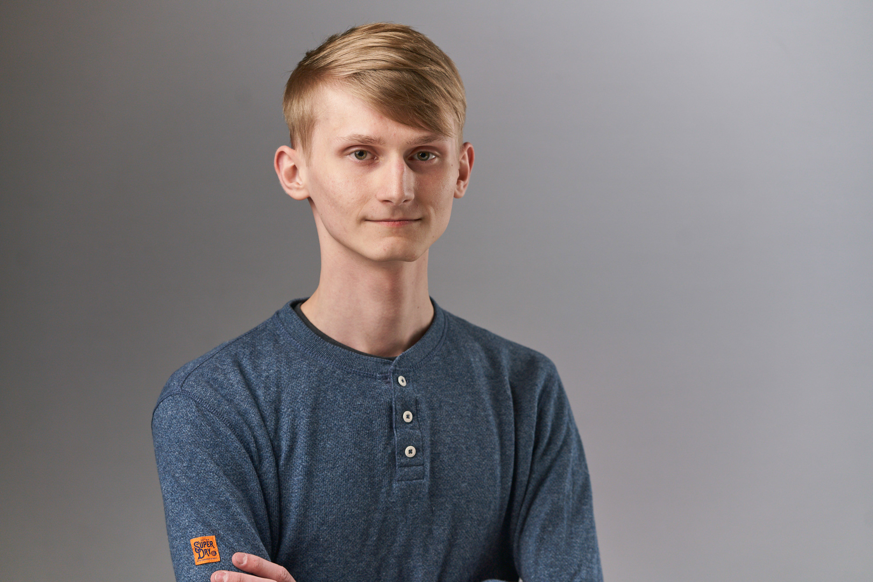 A photo of Nikita Kotter smiling, with his arms folded