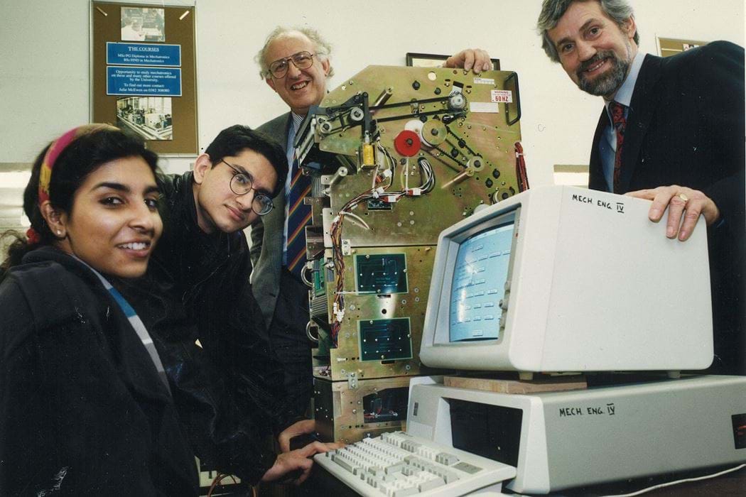 Two students, female and male, with two male lecturers in the mechanical engineering department of Dundee Institute of Technology (Abertay University) with a built ATM machine (inner parts only) and desktop computer. 