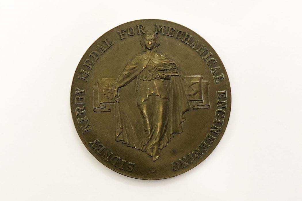 Front of a bronze medal awarded to Mechanical Engineering students at Dundee technical College (Abertay University) Shows female figure at centre with "Sidney Kirby Mechanical Engineering" text around the edge. 