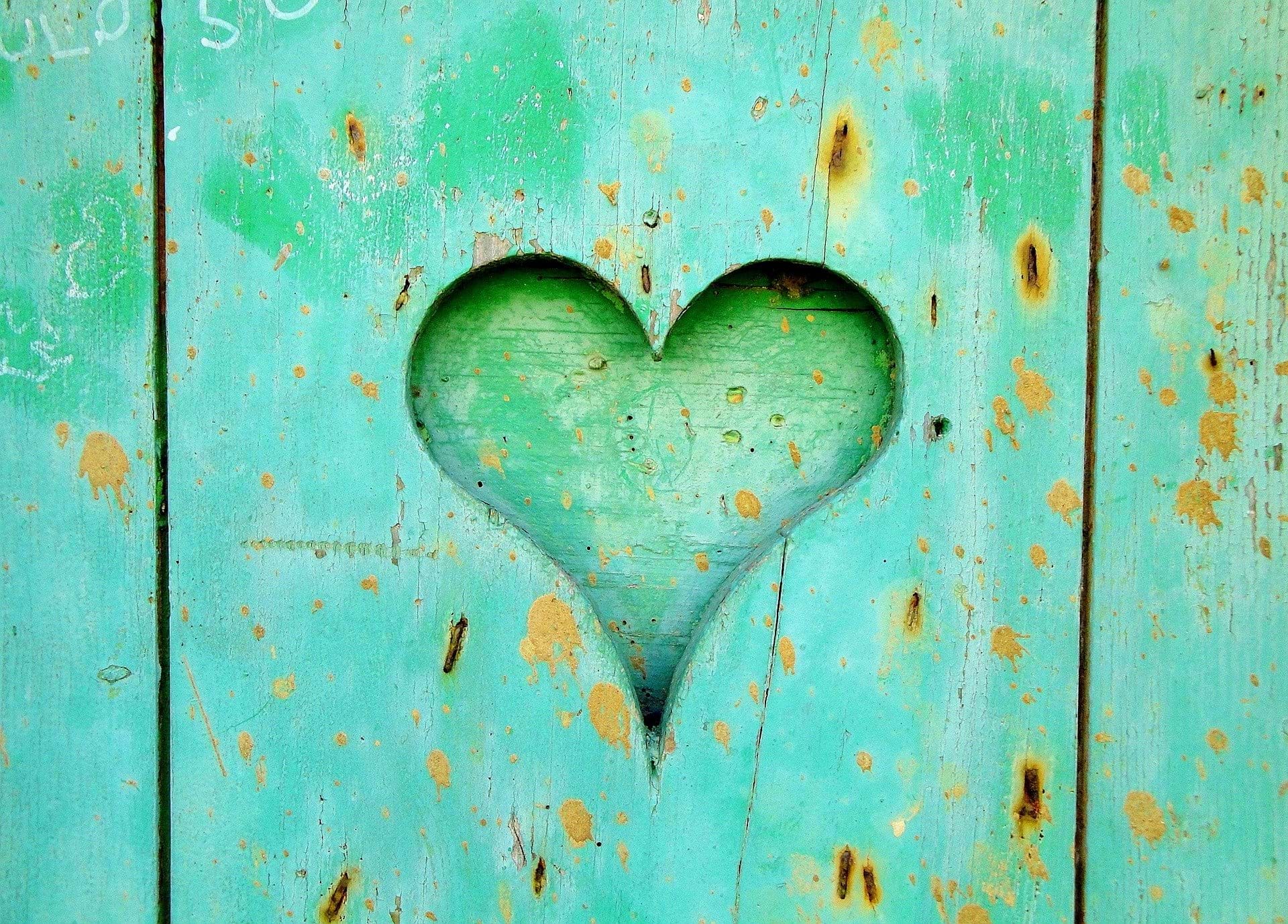 A green heart carved into wood