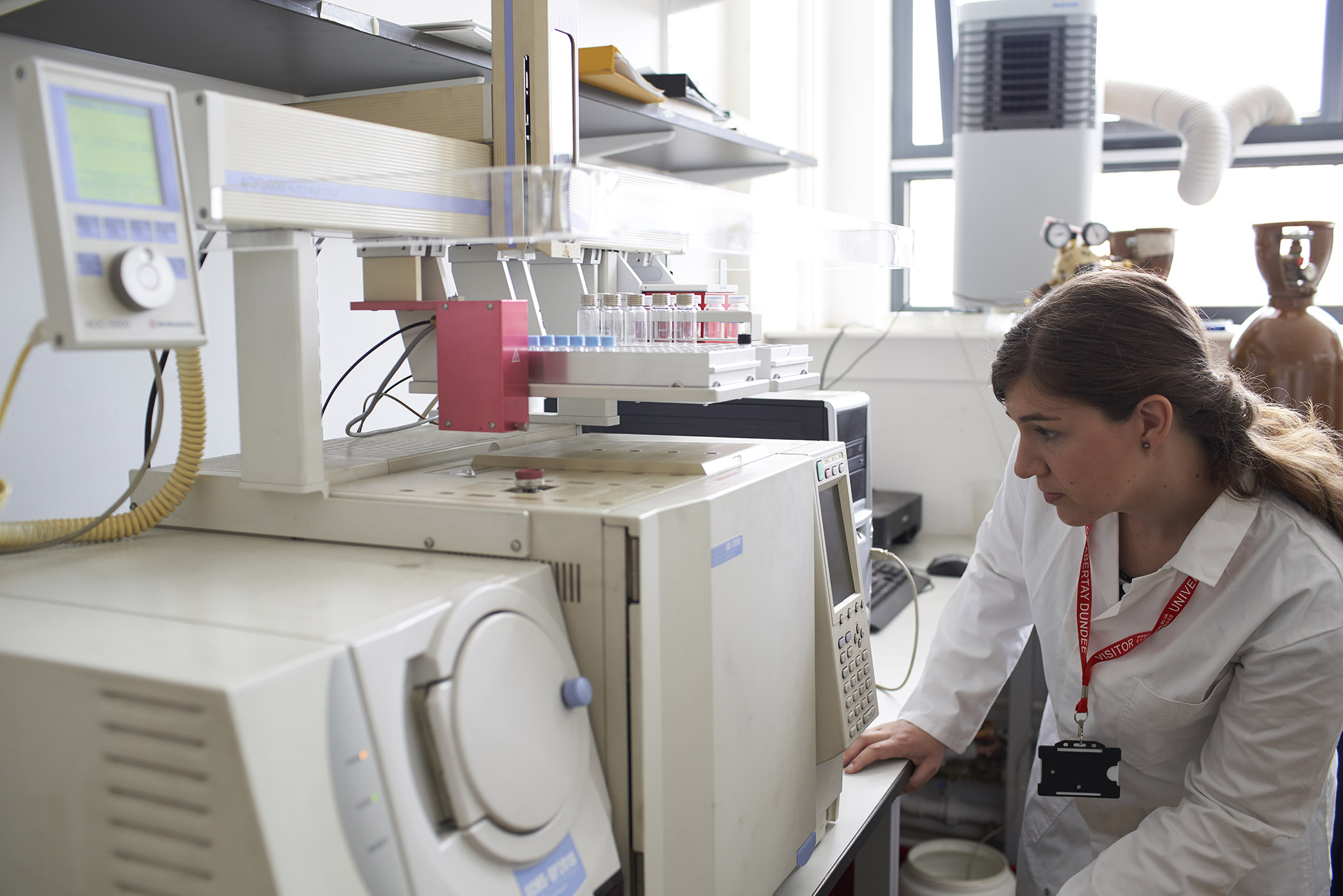 student in lab with large equipment