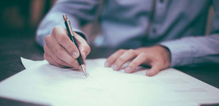 A photo of someone signing papers.