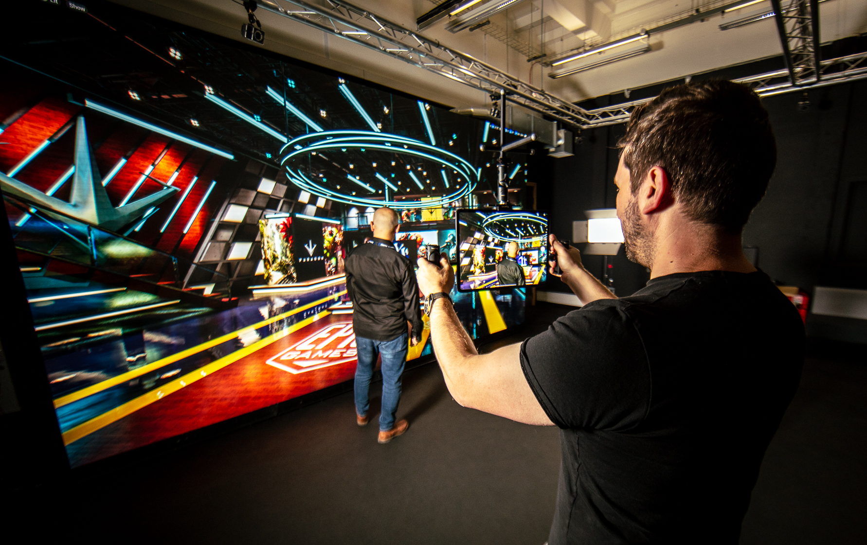 A movie scene shot in Abertay's virtual production research environment showing a large LED screen and an academic with a tablet